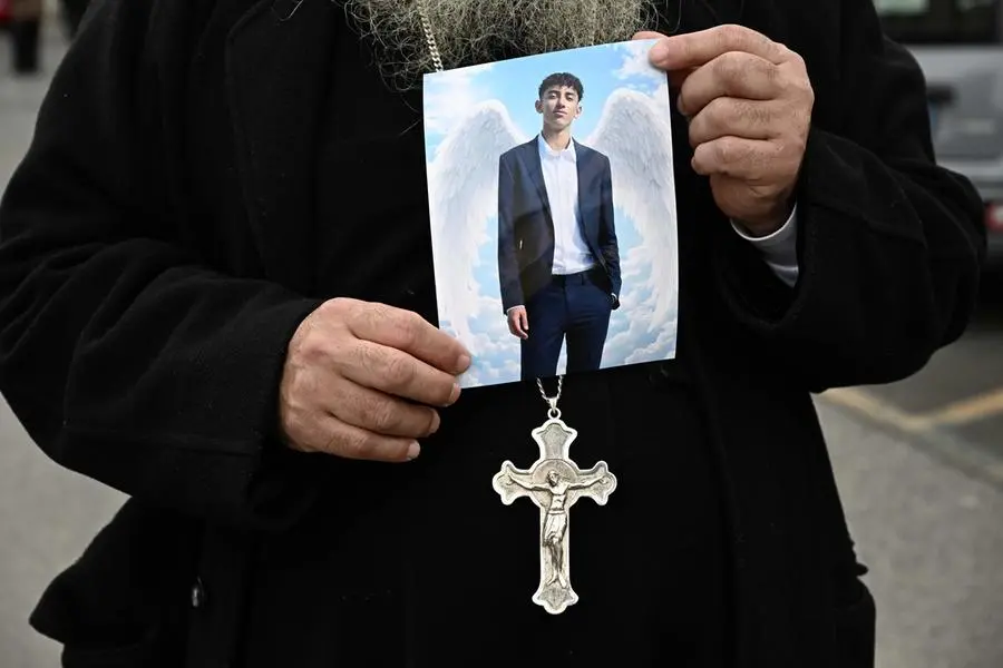 Un prete cristano copto, la comunita\\' religiosa egiziana di cui faceva parte, mostra la foto di Youssef Abanoub, ucciso da un compagno di scuola con una coltellata. , ANSA