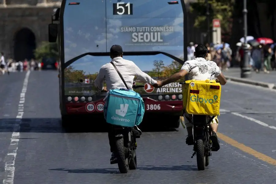 Due rider su via dei Fori Imperiali, a Roma, durante la prima ondata di caldo di quest'estate