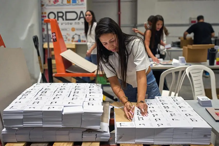 A worker prepares sheets of newly printed ballots seen at a printing house ahead of Israel's general election, in Kiryat Gat, southern Israel, Monday, Oct. 5, 2026. (AP Photo/Ohad Zwigenberg)