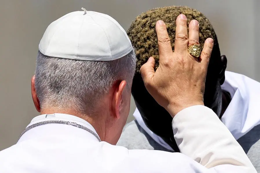 Papa Leone XIV benedice uno dei migranti, con il quale ha fatto un\\'offerta floreale ai migranti dispersi in mare, sul molo del porto di Arguineguin a Gran Canaria, Spagna, l\\'11 giugno 2026. REUTERS/Yara Nardi , REUTERS