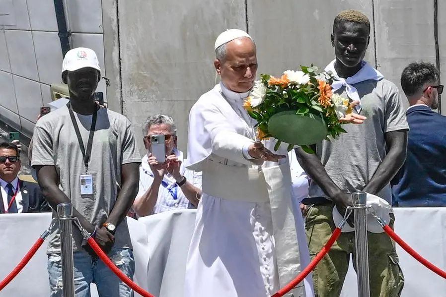 Papa Leone lancia una corona di fiori in mare, affiancato da due migranti, nel porto di Arguinegu\\u00EDn, a Gran Canaria, in memoria delle vittime delle rotte migratorie. Spagna, 11 giugno 2026. , ANSA