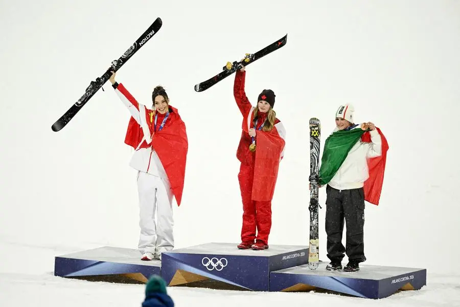 Milano Cortina 2026 Olympics - Freestyle Skiing - Women's Freeski Big Air Victory Ceremony - Livigno Snow Park, Livigno, Italy - February 16, 2026. Gold medalist Megan Oldham of Canada celebrates on the podium after winning the Women's Freeski Big Air Final with silver medalist Ailing Eileen Gu of China and bronze medalist Flora Tabanelli of Italy REUTERS/Dylan Martinez