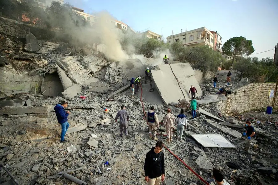 Soccorritori e civili tra le macerie dopo un raid israeliano nel villaggio di Ain Qana, nel sud del Libano. , Ansa