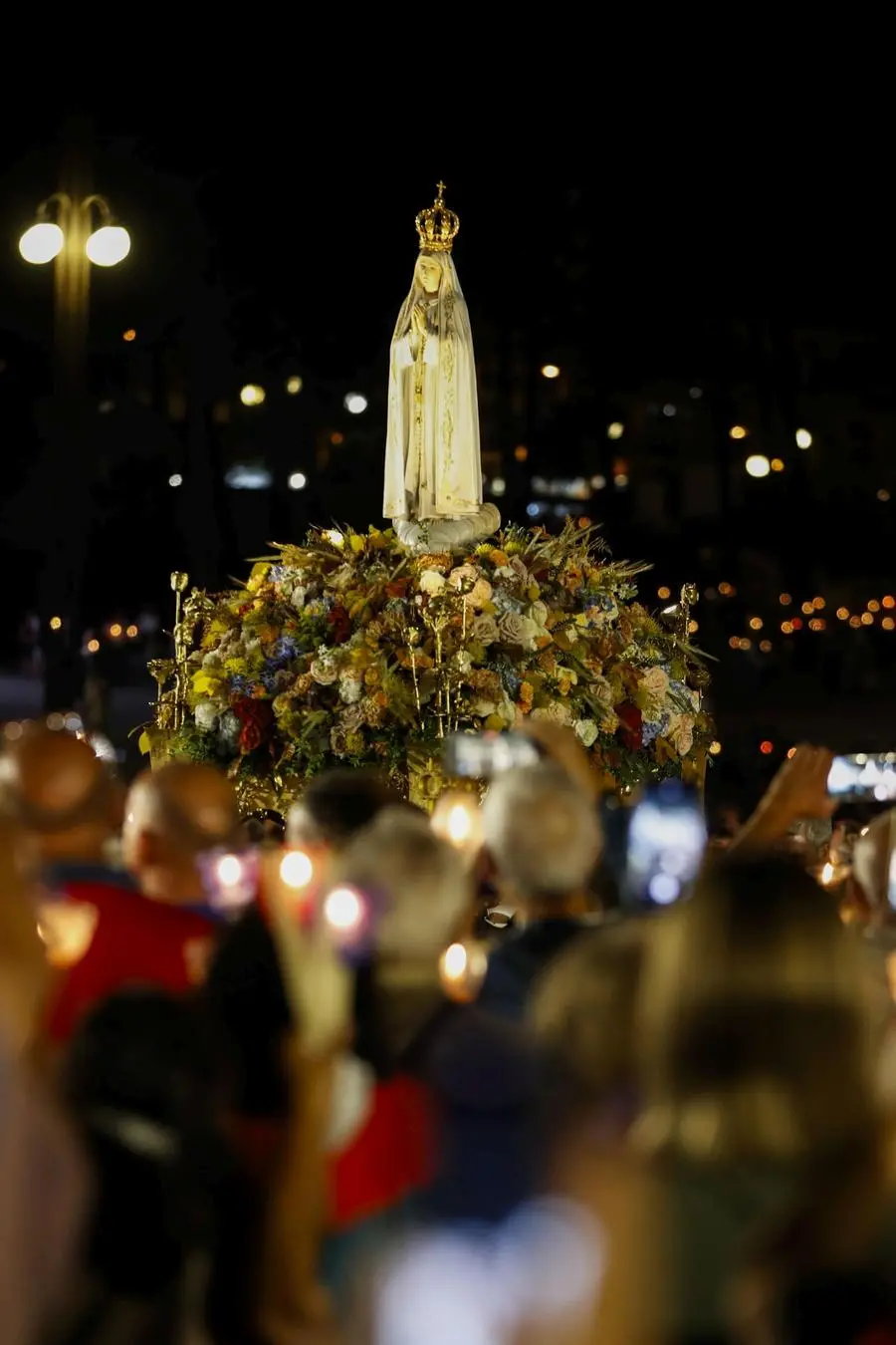 epa12296548 Pilgrims participate in the candlelight procession in honor of Our Lady of Fatima during the International Anniversary Pilgrimage at the Sanctuary of Fatima in Fatima, Portugal, 12 August 2025. The International Anniversary Pilgrimage in August celebrates the apparition of Our Lady of Fatima to the young shepherds. EPA/PAULO CUNHA