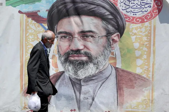 epa13046115 An Iranian man walks past a poster of Iranian supreme leader Ayatollah Mojtaba Khamenei in a street in Tehran, Iran, 18 June 2026. Iran and the US signed a peace agreement to end the war between the two countries. EPA/ABEDIN TAHERKENAREH RESTRICTIONS: NO Access Israel Media/Persian Language TV Stations Outside Iran/Strictly No Access BBC Persian/VOA Persian/Manoto TV/Iran International TV. (As mandated by Iran's Directorate General for Foreign Media) --