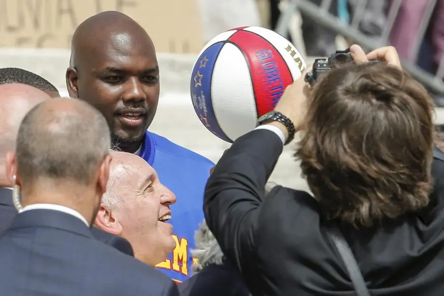 Pope Francis smiles as he plays with a ball next to a member of the Harlem Globetrotters basketball team during the weekly audience in Saint Peter's Square at the Vatican May 6, 2015. REUTERS/Giampiero Sposito TPX IMAGES OF THE DAY