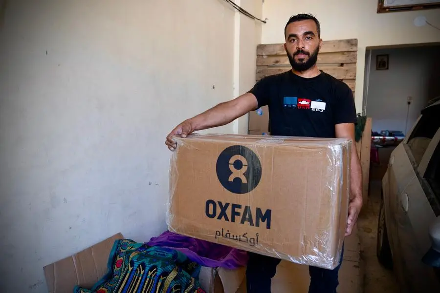 Raed Mansour holds the Oxfam food parcel distributed to displaced people. He and his wife are having great difficulty preparing food for their three children, who have lost a lot of weight during Israel's war on Gaza.