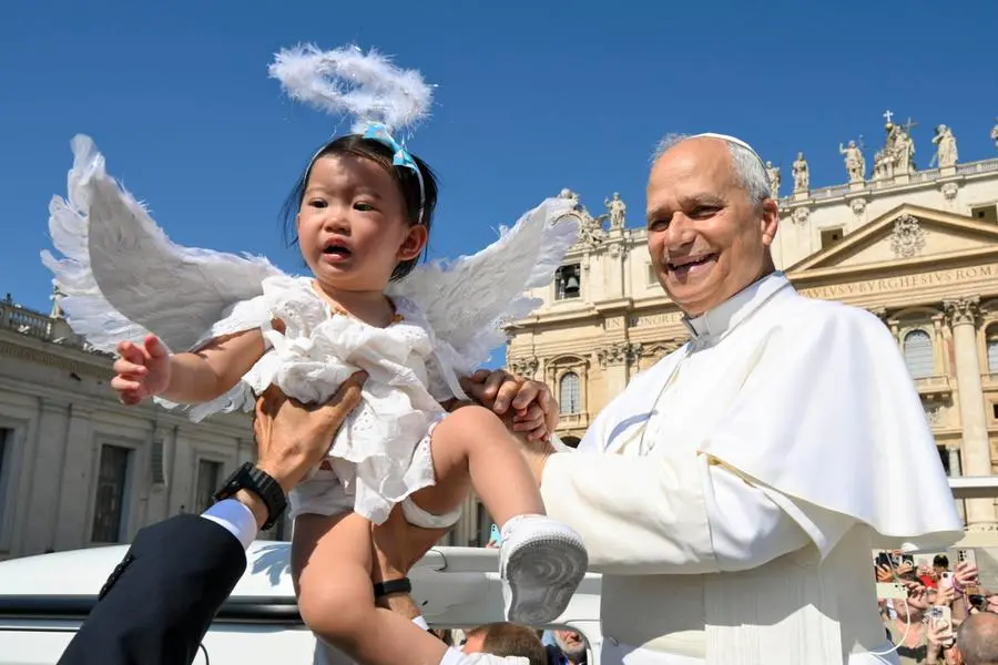 Papa Leone in Piazza san Pietro prende in braccio una bambina. , ANSA
