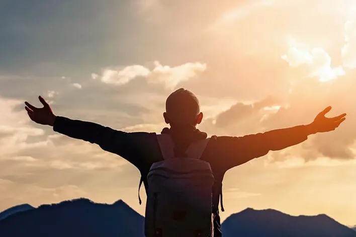 Backpacker man raise hand up on top of mountain with sunset sky and clouds abstract background. Copy space freedom travel adventure and feel good concept. Vintage tone filter effect color style. , tonktiti - stock.adobe.com