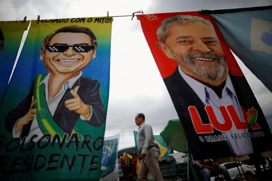 FILE PHOTO: A man walks past presidential campaign materials depicting Brazil's former President Luiz Inacio Lula da Silva and and President Jair Bolsonaro in Brasilia, Brazil, September 23, 2022. REUTERS/Adriano Machado/File Photo