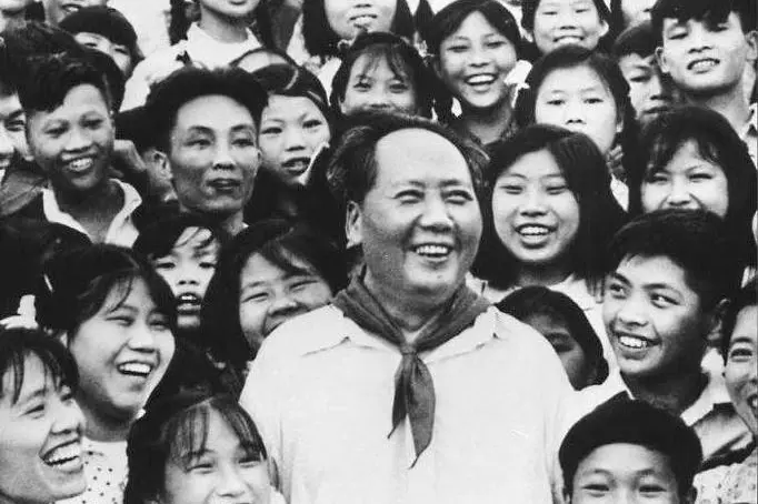 Una fotografia del 1959 mostra il presidente Mao Zedong tra insegnanti e studenti di una scuola. ANSA / XINHUA