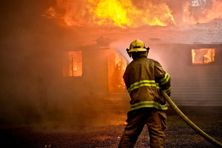 Un pompiere al lavoro per tentare di spegnere un incendio , Getty Images/iStockphoto