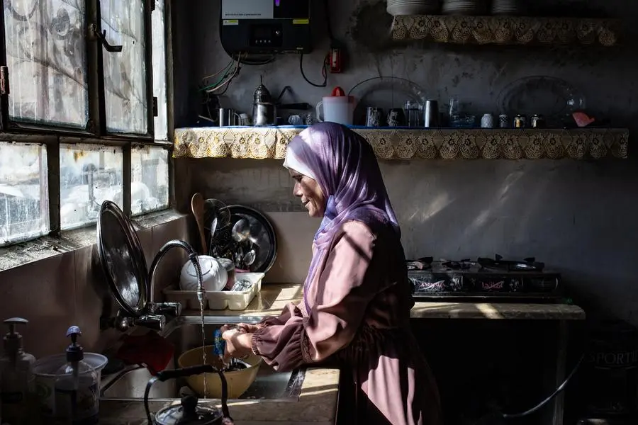 Una donna siriana nella cucina della sua casa che oggi è fornita di acqua corrente.