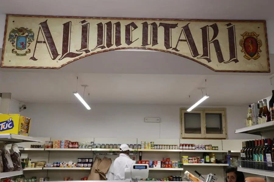 Un\\'insegna di un negozio di alimentari , ANSA