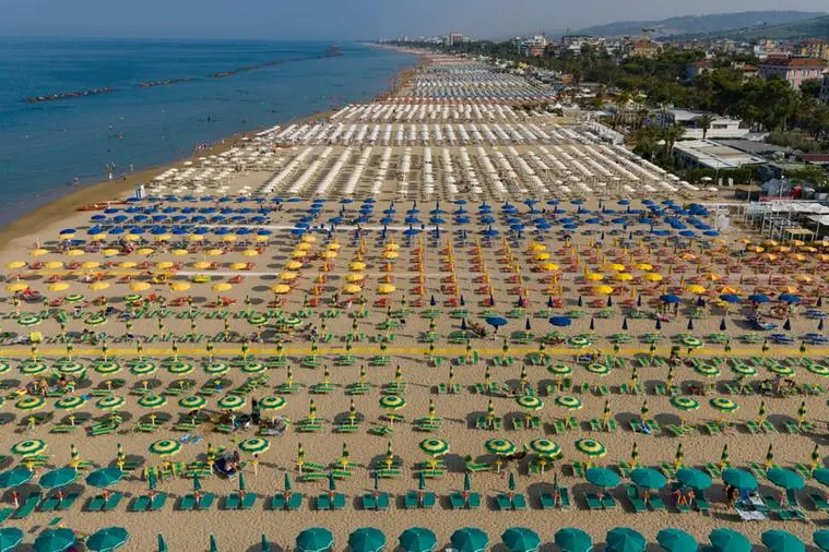 File interminabili di ombrelloni e lettini lungo il litorale italiano , Getty Images