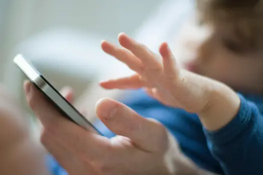 Toddler touching father's cell phone