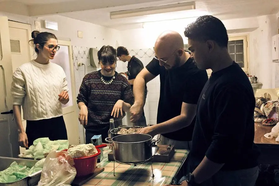 I giovani nella cucina della sede della Caritas diocesana di Genova preparano la cena da portare ai poveri.