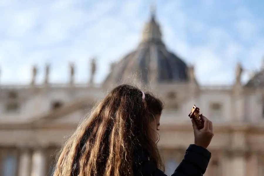 Una bambina espone il Ges\\u00F9 bambino del presepe alla benedizione di Papa Leone all\\'Angelus che precede il primo Natale di papa Prevost , REUTERS