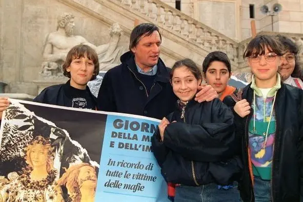Un giovane don Luigi Ciotti con i ragazzi in una delle prime giornate della memoria e dell\\'impegno
