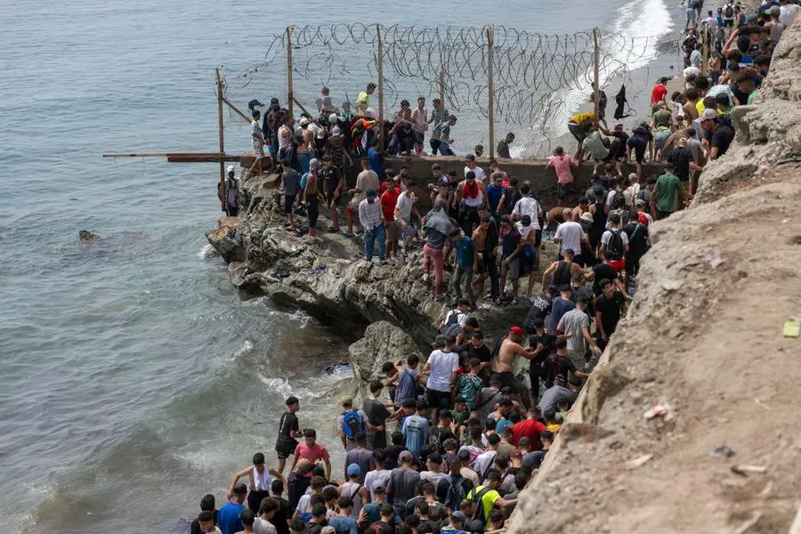 epa13144339 Young men who returned from Spain gather at the Bab Sebta border crossing near Fnideq, Morocco, 31 July 2026. The unrest erupted as thousands gathered near the border, some attempted to cross into Ceuta and clashed with Moroccan security forces. EPA/JALAL MORCHIDI , EPA