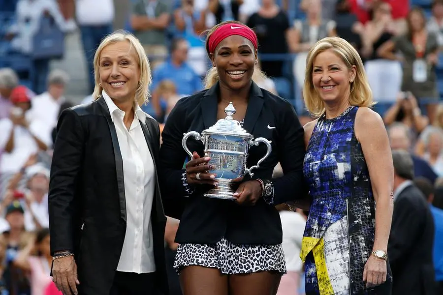 Serena Williams of the U.S. holds her trophy while flanked by tennis greats Martina Navratilova (L) and Chris Evert after Williams defeated Caroline Wozniacki of Denmark in their women's singles finals match at the 2014 U.S. Open tennis tournament in New York, September 7, 2014. REUTERS/Mike Segar (UNITED STATES - Tags: SPORT TENNIS)