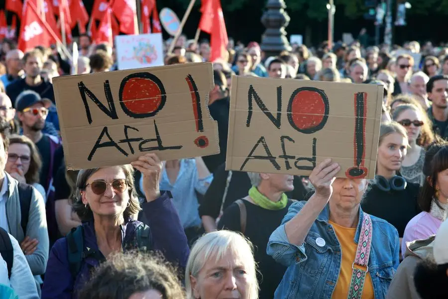 Manifestanti con cartelli «No AfD» durante la protesta alla Porta di Brandeburgo, a Berlino, il 7 settembre 2026, all’indomani della vittoria dell’AfD alle elezioni regionali in Sassonia-Anhalt