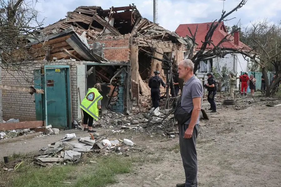 Residenti davanti alle macerie di abitazioni colpite dai droni russi nella regione di Kharkiv.