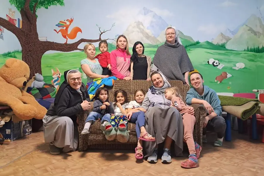 Suor Kamila, seduta a destra, suor Sabina, a sinistra, e suor Lidia, in piedi, con alcune mamme e i loro figli nella casa di Korotych. , Stanislaw Marcisz