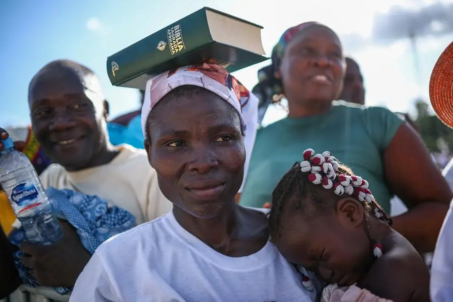 A woman with the Bible on her head waiting for the rosary.