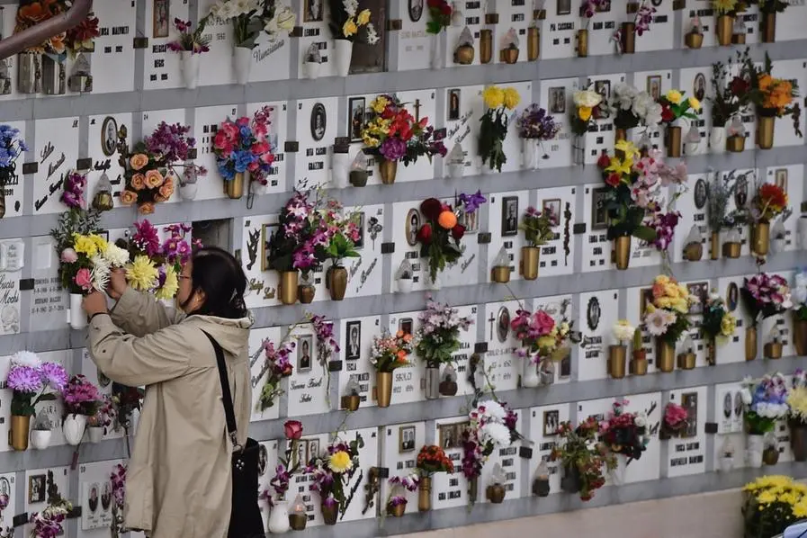 Persone al cimitero di Firenze depongono fiori in occasione del 2 novembre