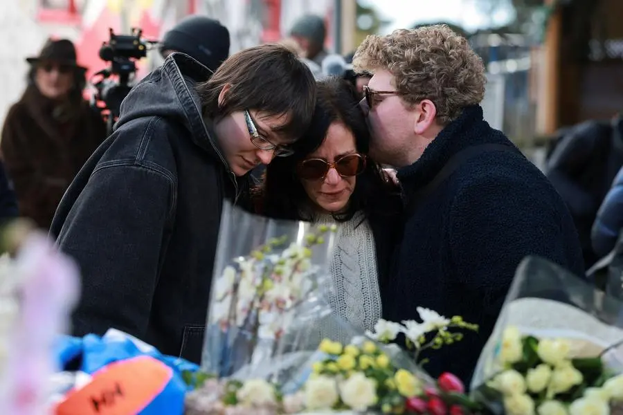 Persone in lacrime lasciano un fiore davanti al luogo della tragedia , REUTERS