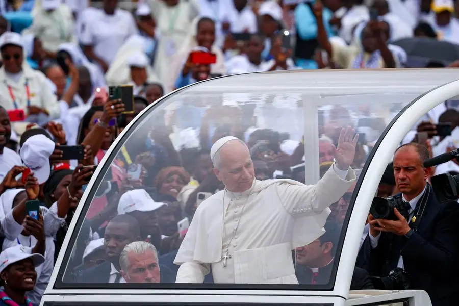 Papa Leone sulla papamobile saluta i fedeli riuniti a Kilamba per la messa. , REUTERS