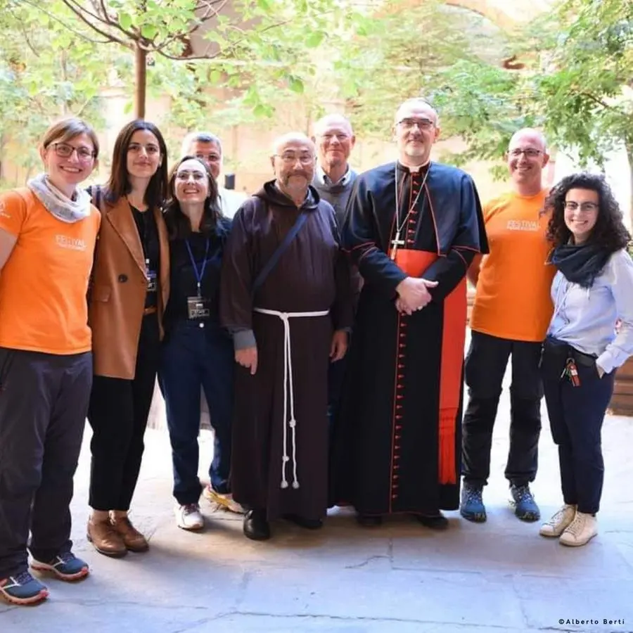 Nella foto: fra Dino Dozzi e alcuni volontari insieme con il cardinale Pierbattista Pizzaballa, patriarca latino di Gerusalemme, intervenuto nel 2024. Sarà presente anche all’edizione di quest’anno.