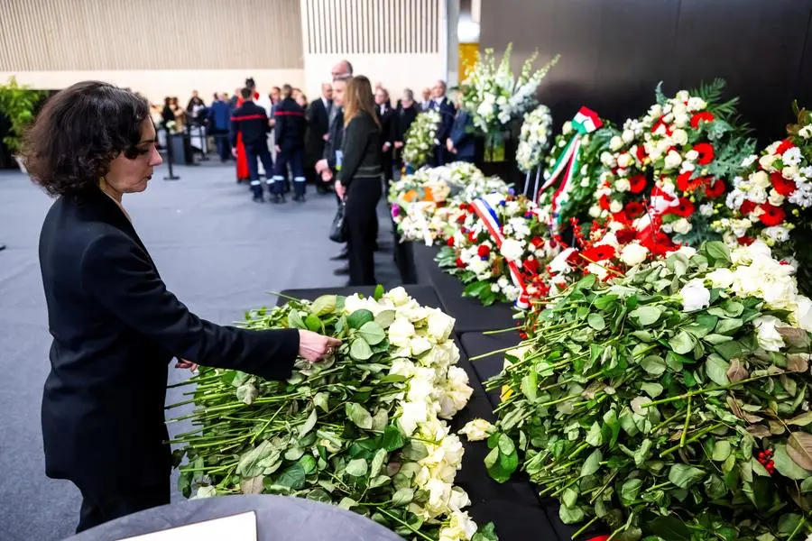 European Commissioner Hadja Lahbib places a white rose in homage to the victims after the official commemorative ceremony for the victims of the Crans-Montana New Year's Eve massacre which took place in Martigny on 9 January