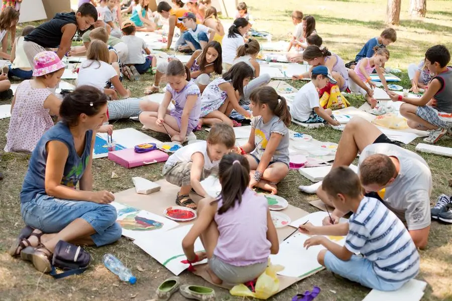 Kragujevac, Serbia - August 16, 2011: Children from 8 to 11 years old participating in a creative workshop on the theme of nature. The workshop was organized by \"Association of young enthusiasts\" from Kragujevac, Serbia. The workshop was organized in the main city park during the summer vacation, in order to fill the summer \"free time\" with some creative activities. Children sitting on the grass and painting with elementar colors: red, yellow and blue , Getty Images