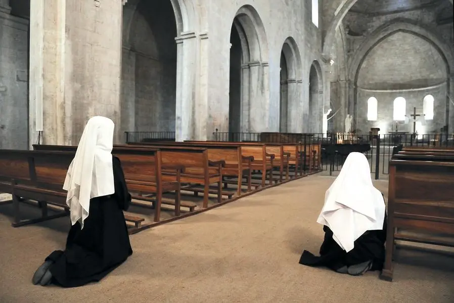 Due suore pregano in Chiesa. , istock