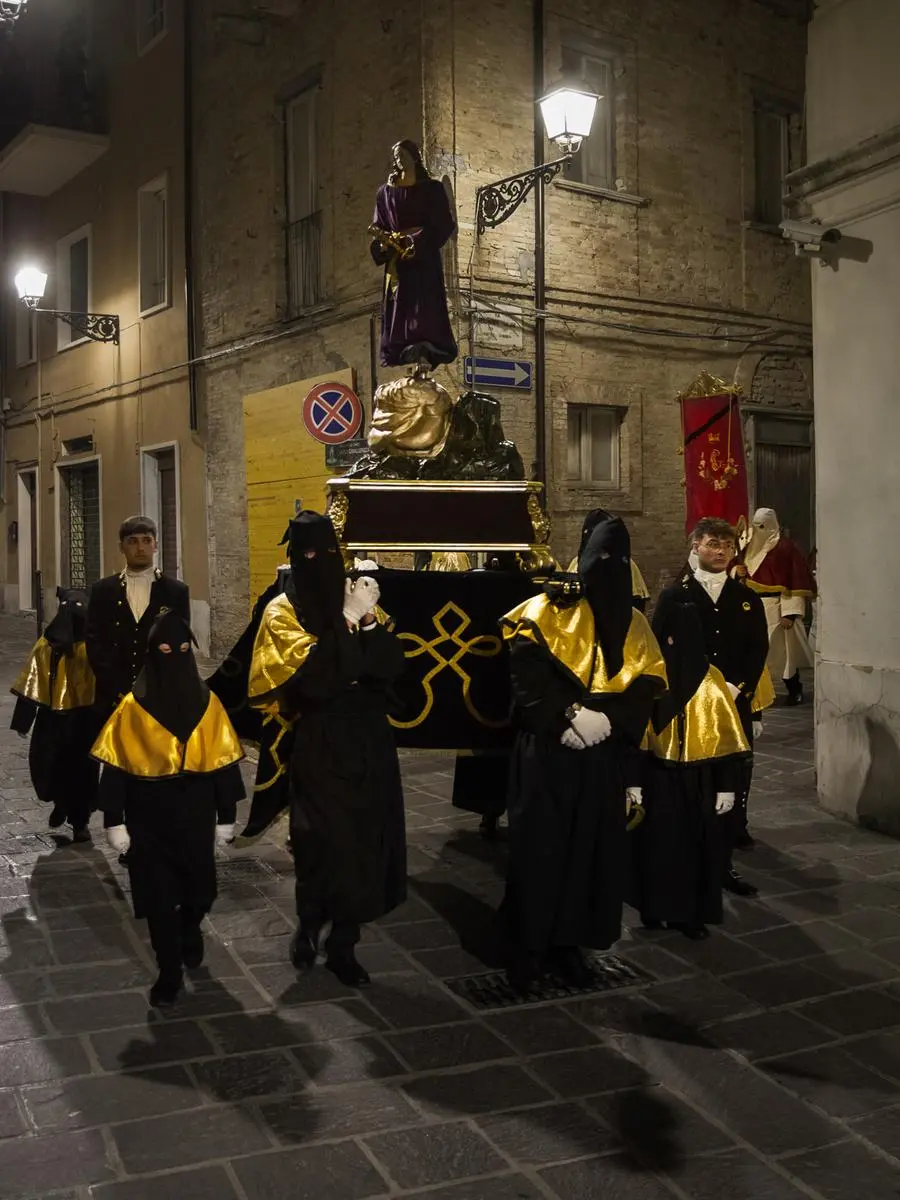Fedeli incappucciati portano in processione la statua della Madonna, Chieti.