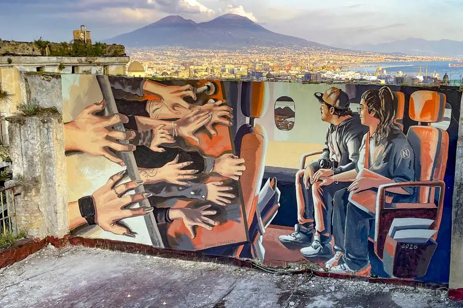 Il murale dal titolo \\\"Le rendite, le mani degli speculatori sulle case dei napoletani\\\" realizzato su un terrazzo panoramico di Napoli dallo street artist Stefano Cammarota, in arte Nino, contro l'overtourism, la gentrificazione e la crisi immobiliare dovuta all'eccesso di appartamenti destinati all'affitto breve, 9 aprile 2026 ANSA