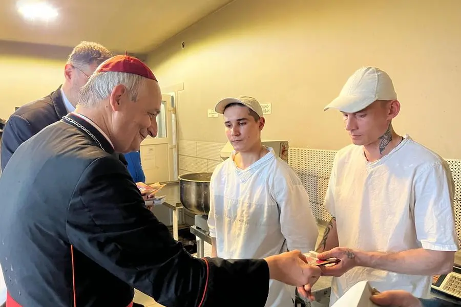 Il presidente della Cei si intrattiene con alcuni detenuti che lavorano nella cucina.