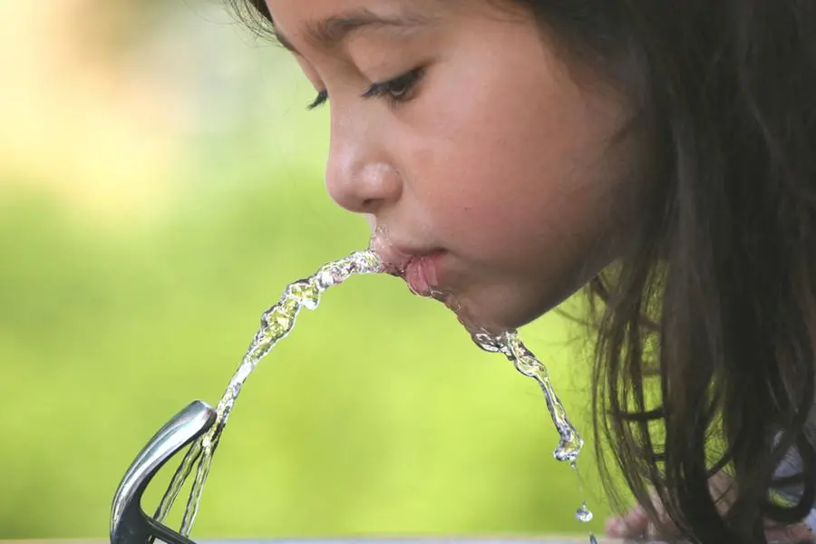 a girl drinking from a water fountain , Getty Images/iStockphoto